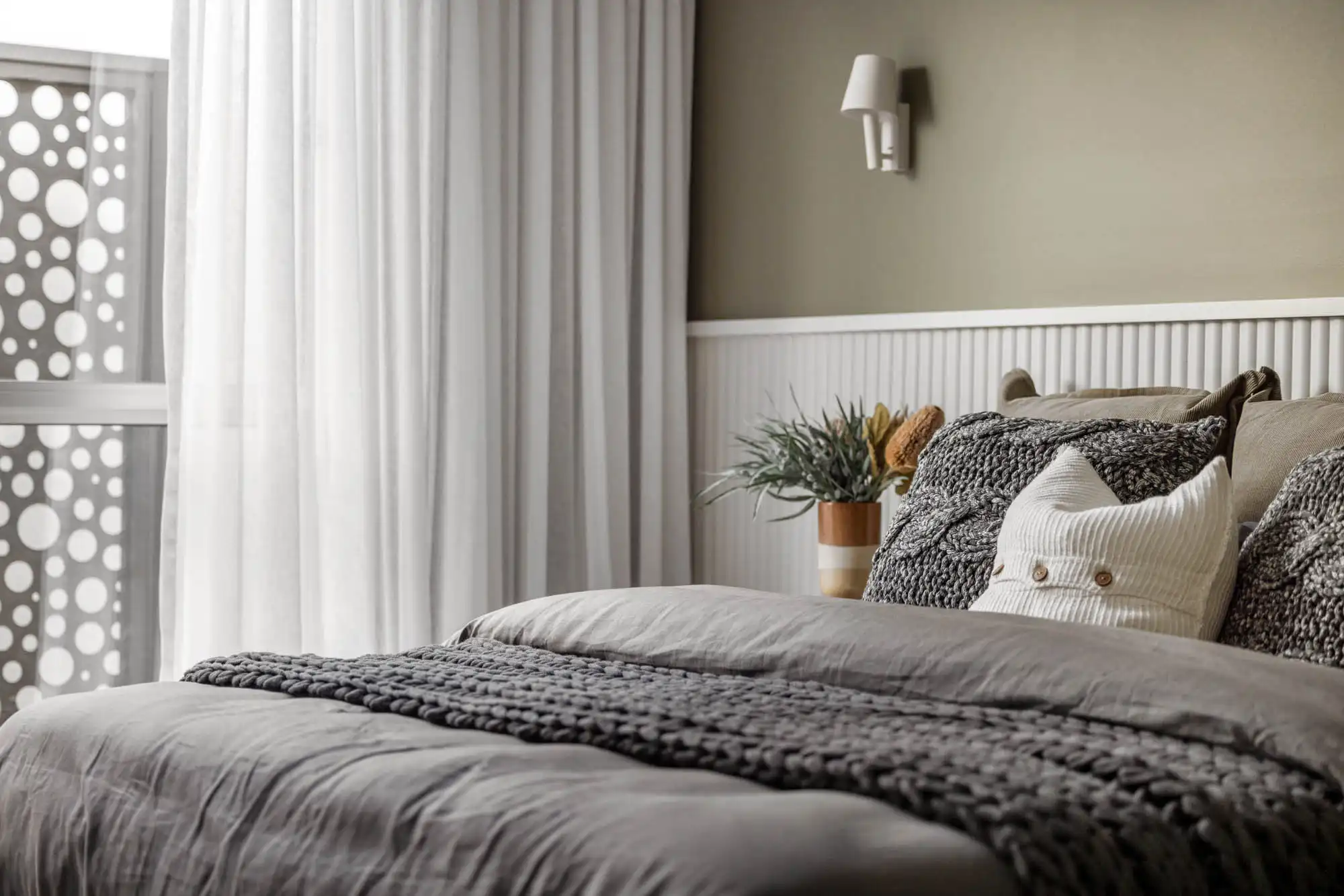 textured pillows and white bead board paneling a two tone design with a natural earthy colour scheme that complements the overall aesthetic of the room at nowra 26