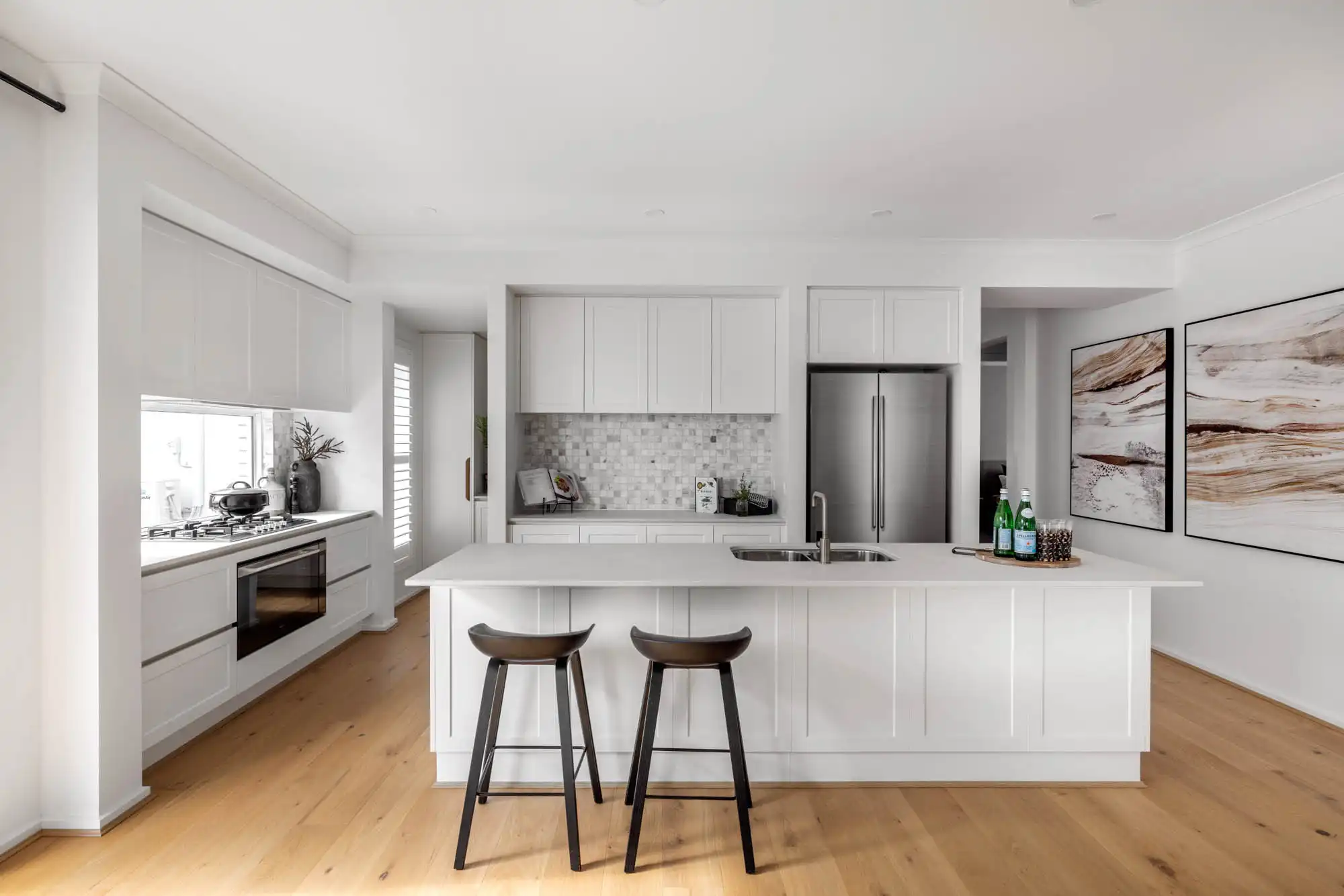 An image of an open living kitchen with wooden flooring that blends modern living as part of Simonds Riverway 26 home design.