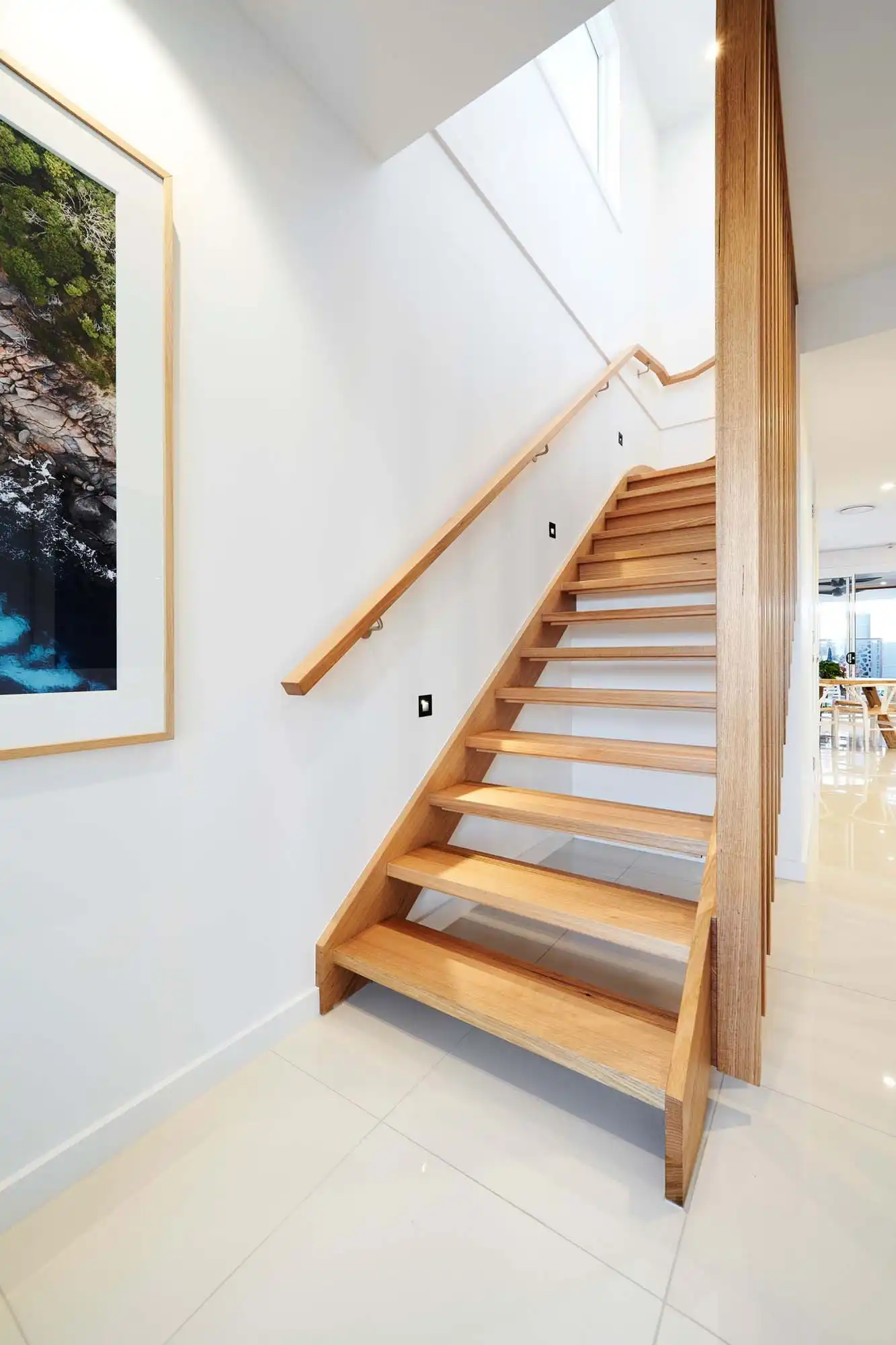 timber staircase with high ceilings and lighting shining through creates a neutral aesthetic for your hallway at alberton 23