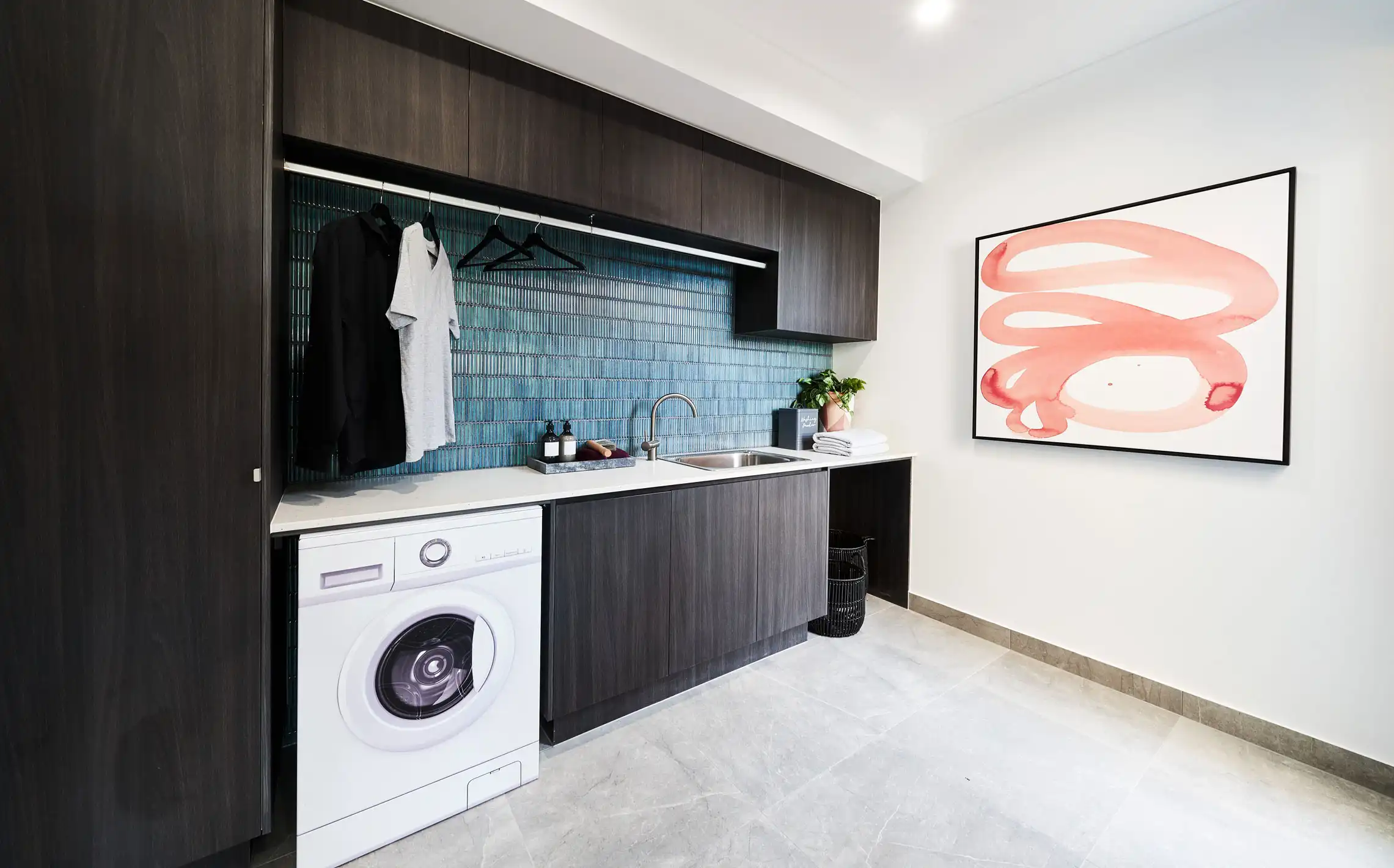 coastal blue kit kat finger tiling laundry with dark warm wood cabinetry