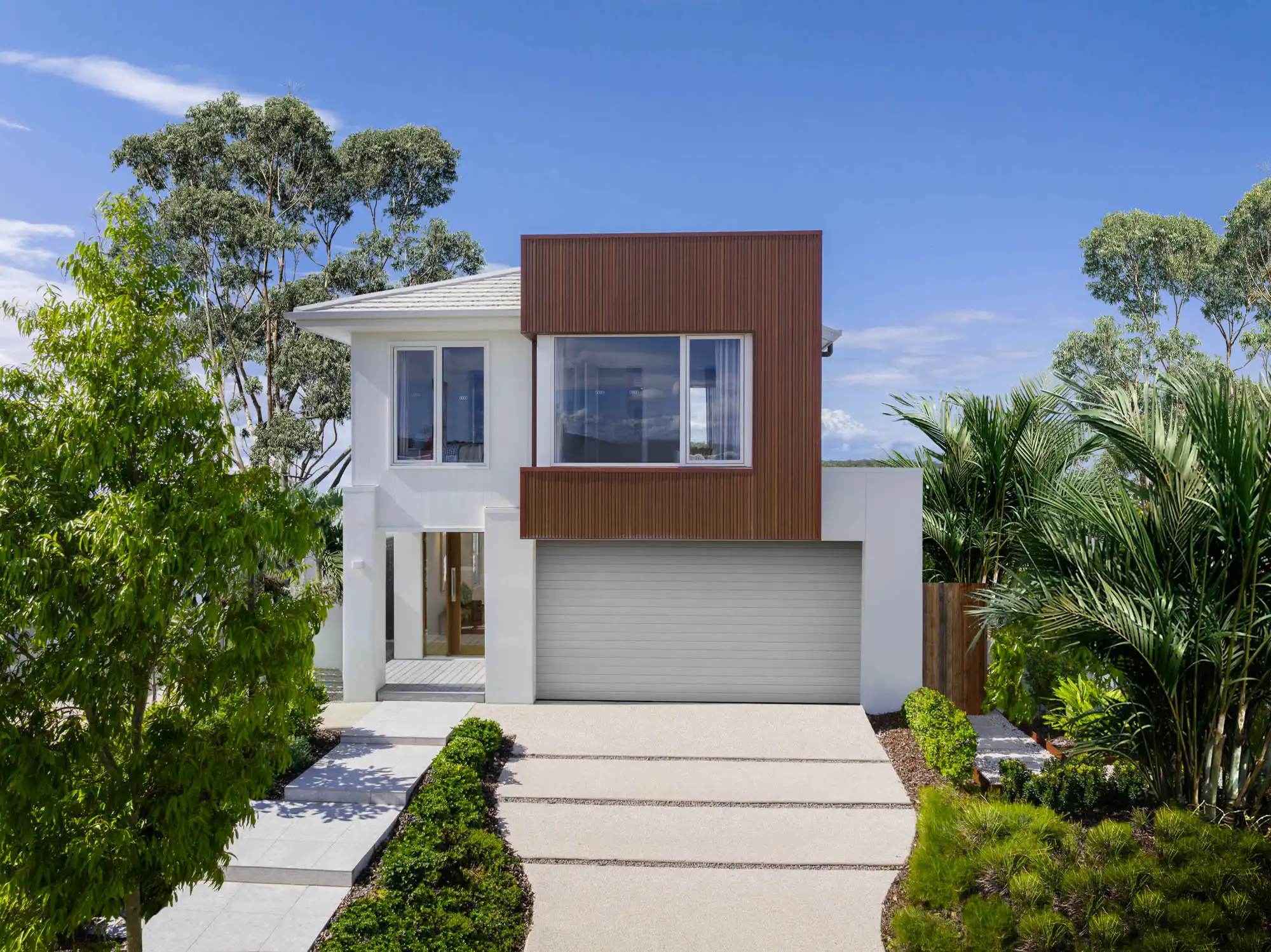 An exterior image of a modern double storey home design with large sliding windows and a garage space as a part of Simonds Travertine 31 facade.