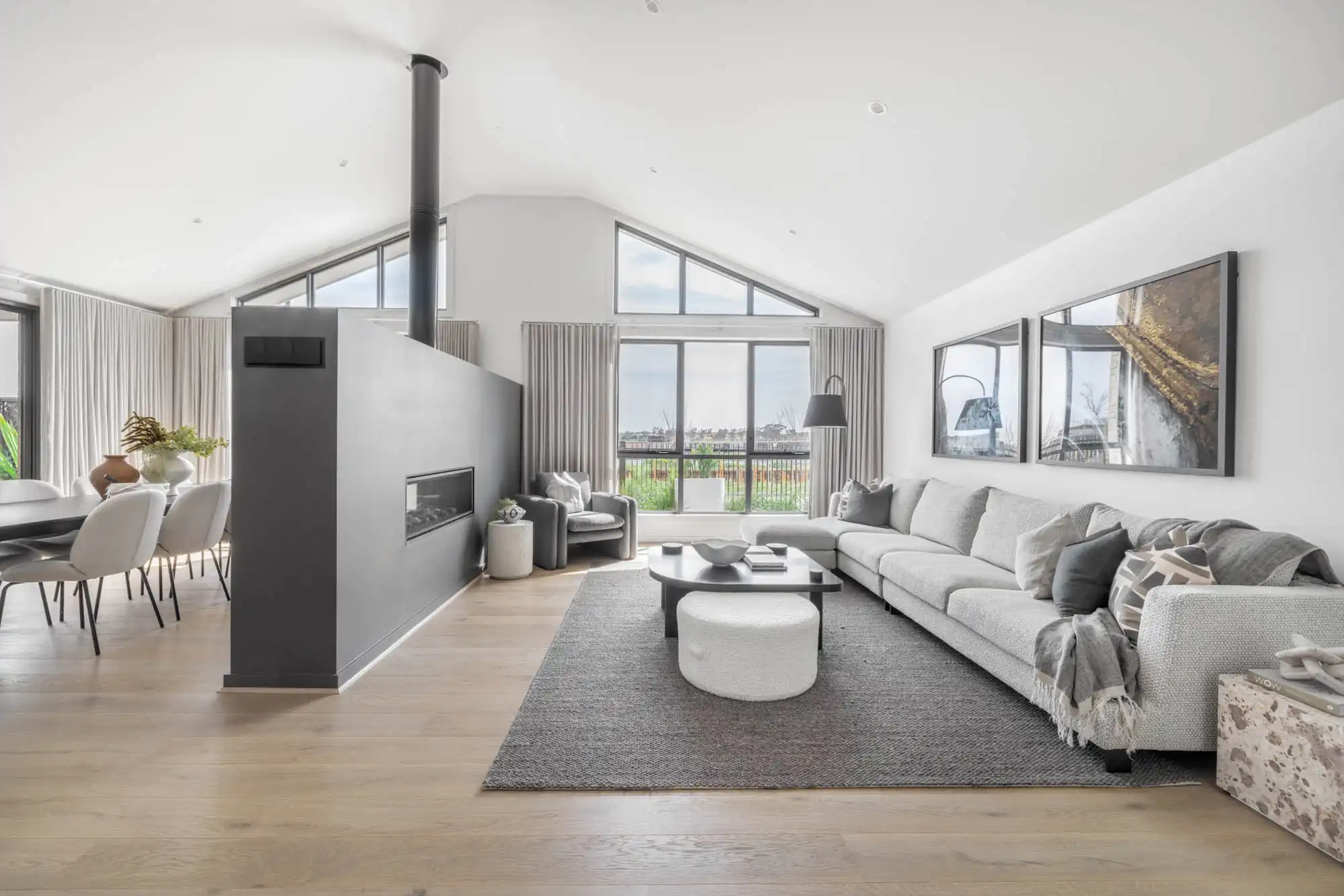 split living and dining room with fireplace and raked ceiling using neutral tones at hampstead 32