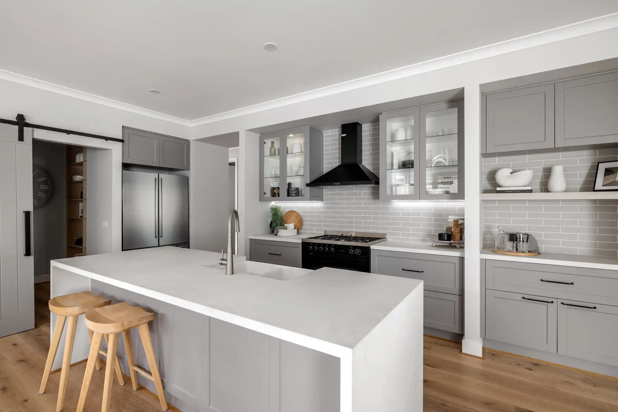 country-style kitchen with farmhouse sinks and barn door to butler's pantry at the akuna 29