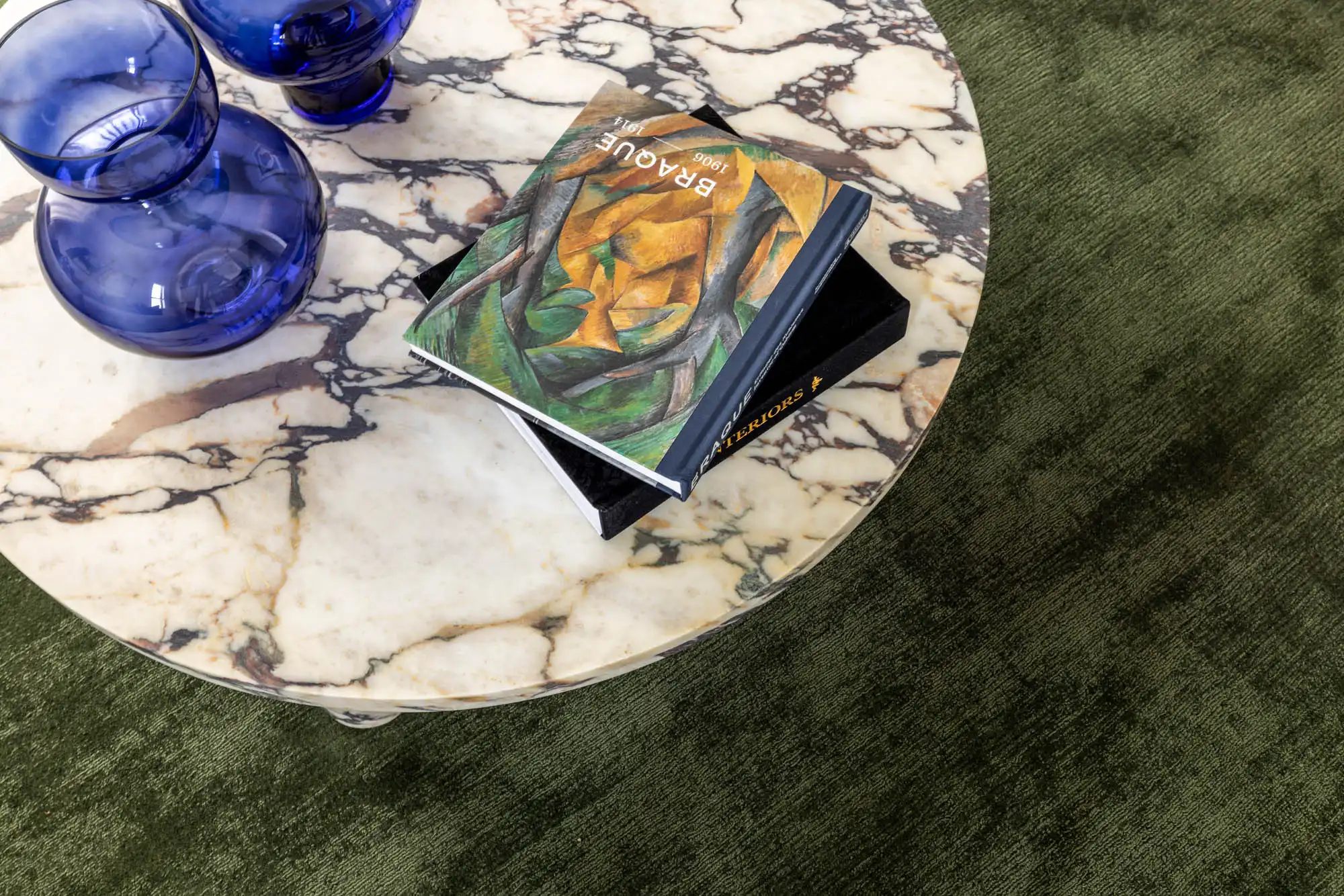 Interior close up photo of luxury glassware and books on top of the marble coffee table and carpet flooring as a part of Armidale 34.