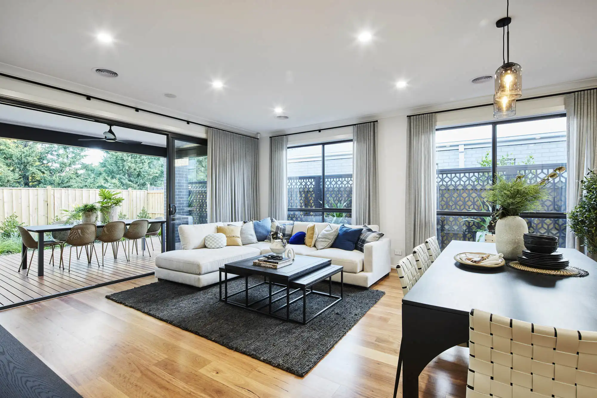 An interior image of a modern open living plan with a dining area and living space blending intoan alfresco setting as part of Simonds Berrima 28 home desiggn.
