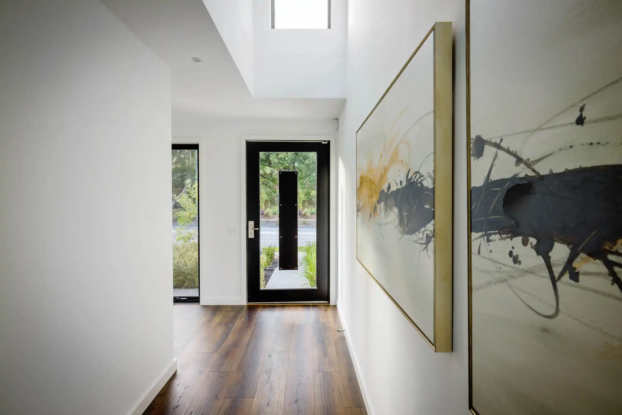 Interior photo of a hallway with wooden floors and unique wall art as part of Masterpiece Milford.