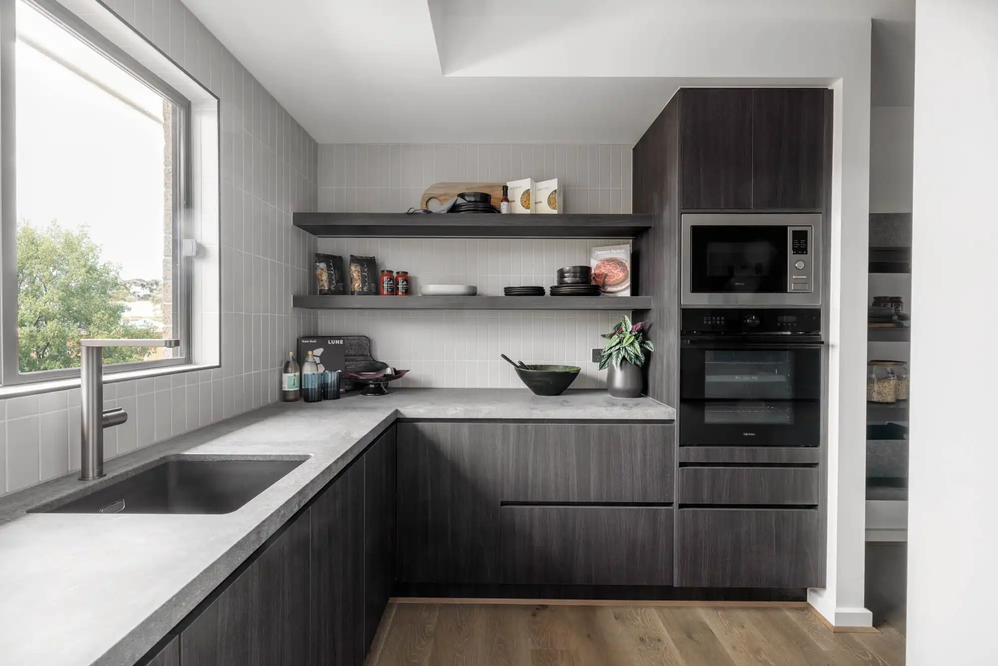 light grey vertical stacked tiling with dark wood cabinets in a walk-in pantry at silverton 45