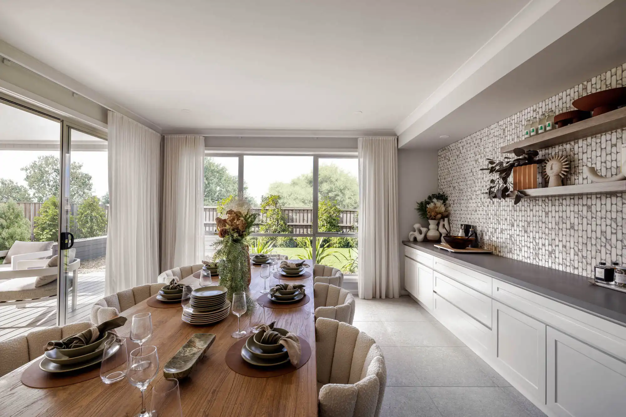 built in bench next to dining room with patterned splash back wall and floor to ceiling curtains at tallowood 52