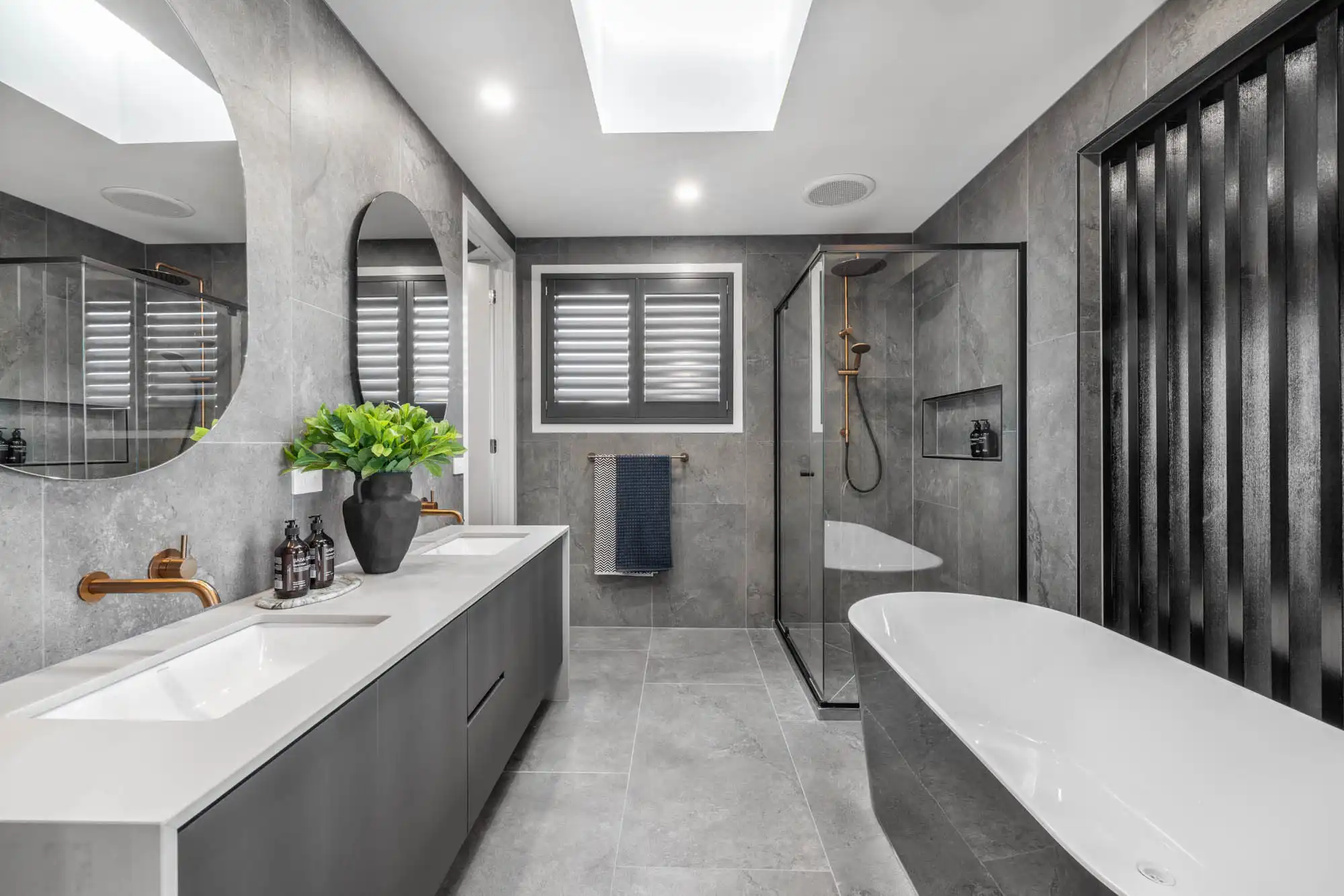 Dual mirrors and sinks with brass faucets to match the dark stoned tiling walkerville 38