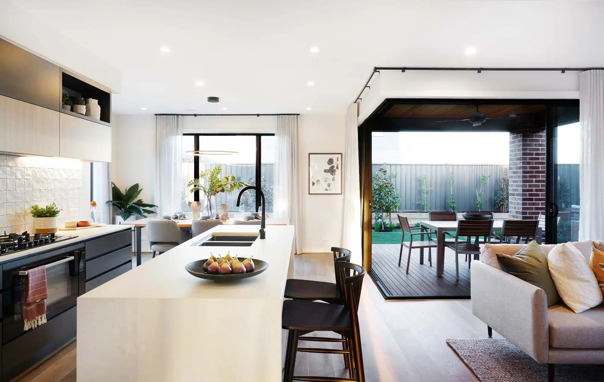 An image of a modern, open living plan with the kitchen blending into the living area and outdoor space as part of Simonds Walkerville 38 home design.