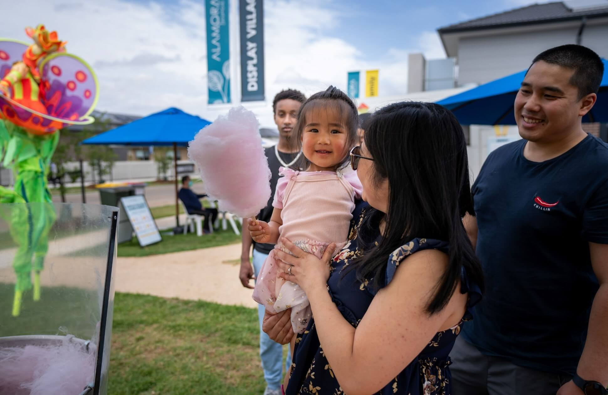 An image of a parents holding their kid at the Alamora display village event.